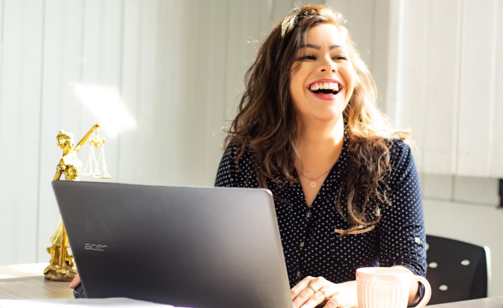 Lächelnde Frau arbeitet am Laptop.